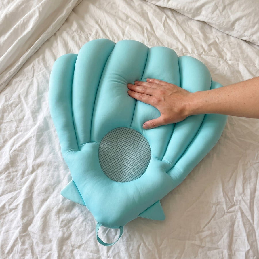 A hand pressing into the soft Sink Bather